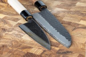 To knive i forskellige kvaliteter på skærebræt i køkken